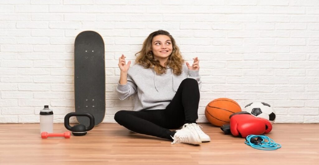 young sport woman sitting floor with fingers crossing 1368 51416